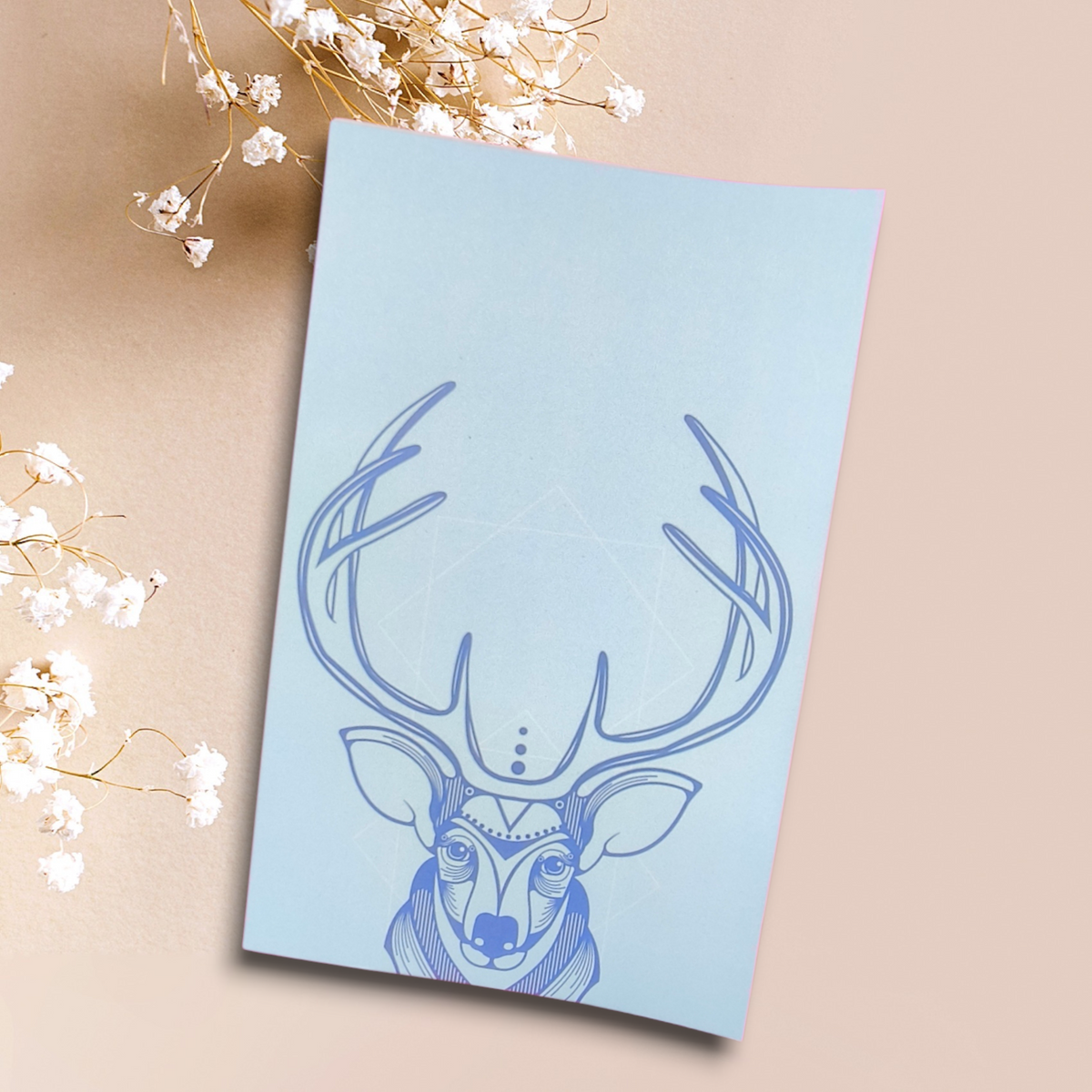 Libreta con venado ilustrado en trazos azules y grandes astas sobre fondo azul claro