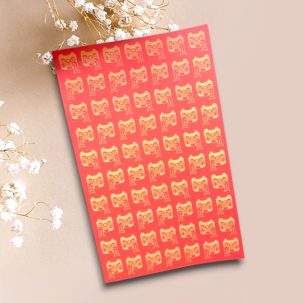 Libreta con patrón de rostros en tonos cálidos sobre portada roja